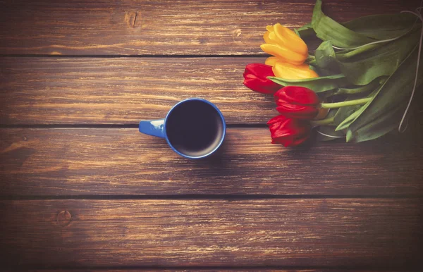 Cup of coffee and tulips — Stock Photo, Image