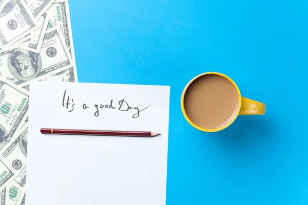 Kopje koffie en papier met inscriptie en dollars — Stockfoto