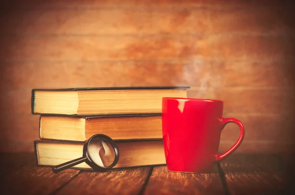 Tasse de café et livre avec loupe — Photo