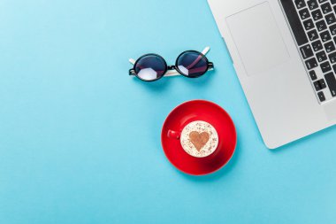 Laptop ve güneş gözlüğü ile kahve