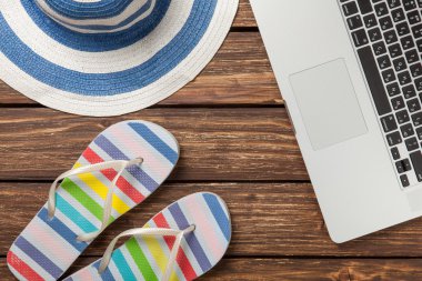 şapka ve ahşap masa üstünde laptop.