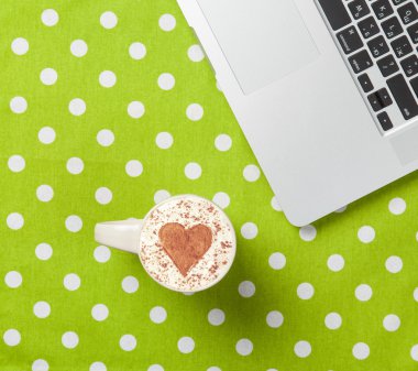 Fincan kapuçino kalp şekli ve dizüstü bilgisayar ile