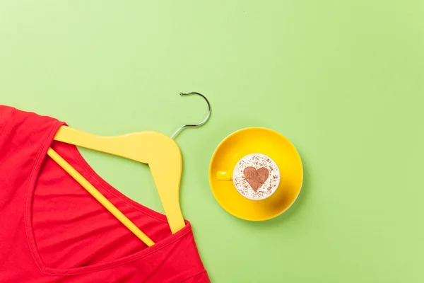 Капучино и желтая вешалка с красным платьем — стоковое фото