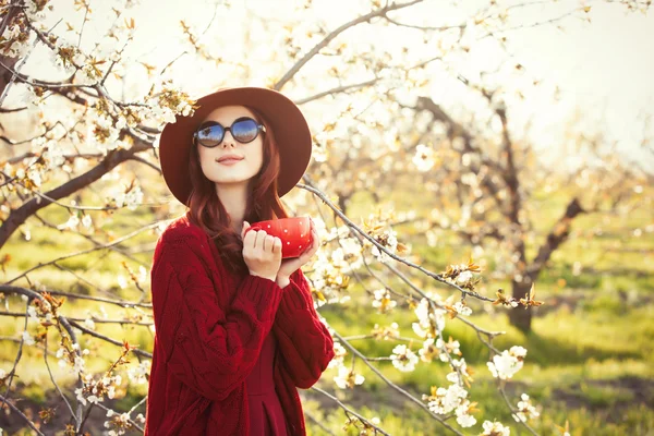 Femme en pull rouge et chapeau avec tasse — Photo