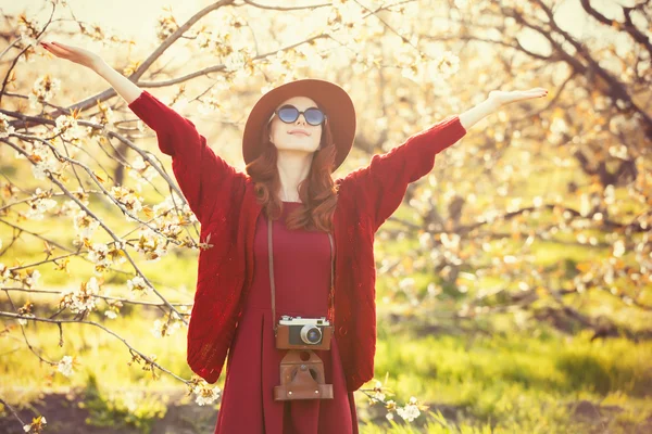 Kobieta z aparatu w ogrodzie drzewa jabłko — Zdjęcie stockowe