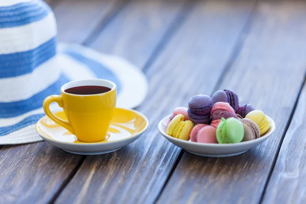 Cup of coffee and macarons with hat — Stock Photo, Image