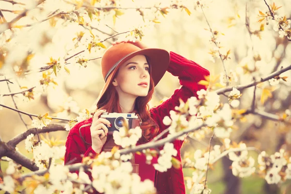 Frau in rotem Pullover und Hut mit Kamera — Stockfoto