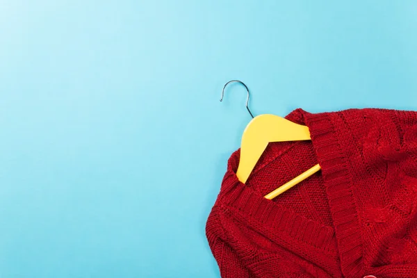 Yellow hanger with red sweater — Stock Photo, Image