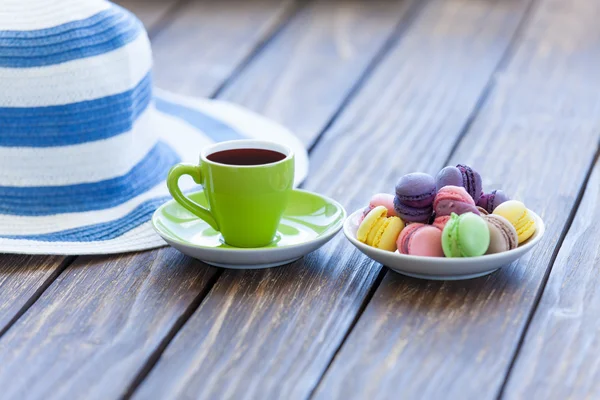 Cup of coffee and macarons with hat — Stock Photo, Image