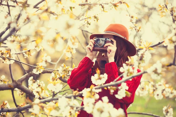 Žena v červený svetr a čepice s kamerou — Stock fotografie