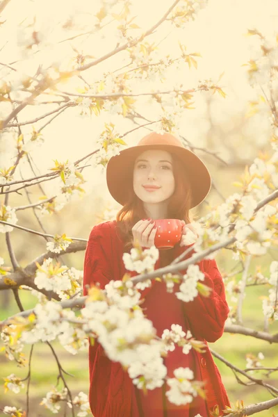 Femme en pull rouge et chapeau avec tasse — Photo