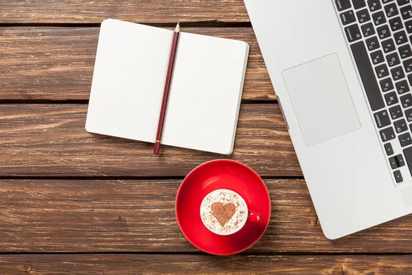 Cappuccino e notebook perto de laptop — Fotografia de Stock