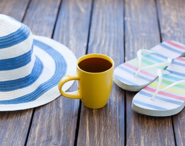 Xícara de café e chapéu com chinelos — Fotografia de Stock
