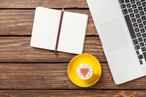 Cappuccino und Notizbuch in der Nähe von Laptop — Stockfoto
