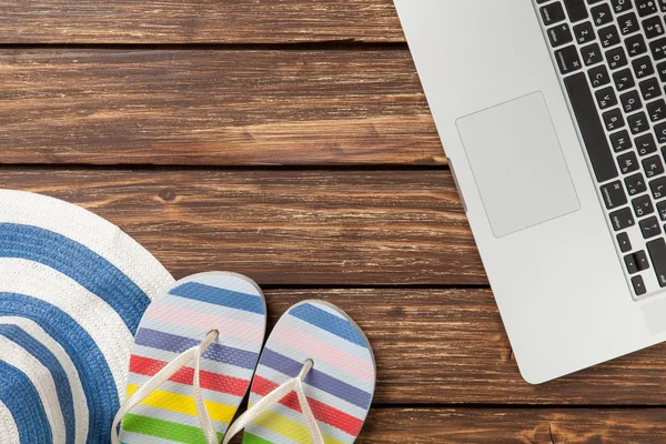 Hat and laptop on wooden table. — Stock Photo, Image