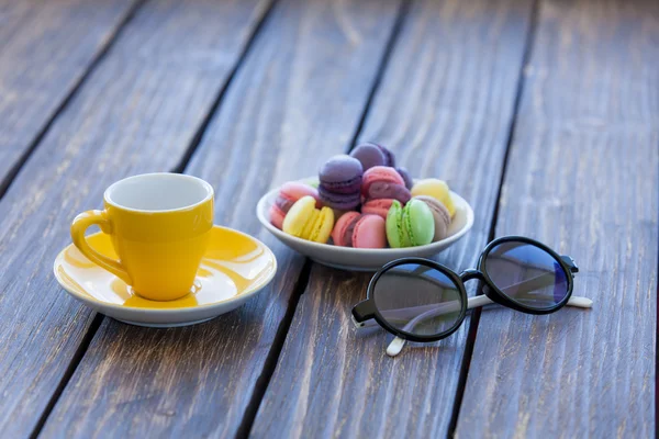 Cup of coffee and macarons with sunglasses — Stock Photo, Image