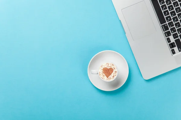 Cappuccino s tvaru srdce a laptop — Stock fotografie