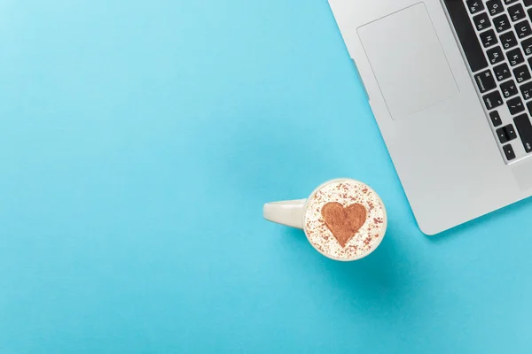 Cappuccino with heart shape and laptop — Stock Photo, Image