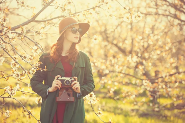 Kobieta z aparatu w ogrodzie drzewa jabłko — Zdjęcie stockowe
