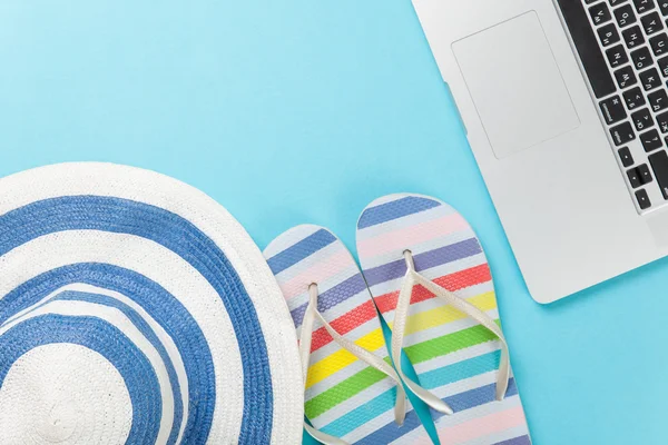 Hatt med flip flops nära laptop — Stockfoto