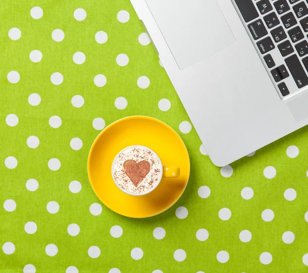 Copa de capuchino con forma de corazón y portátil — Foto de Stock