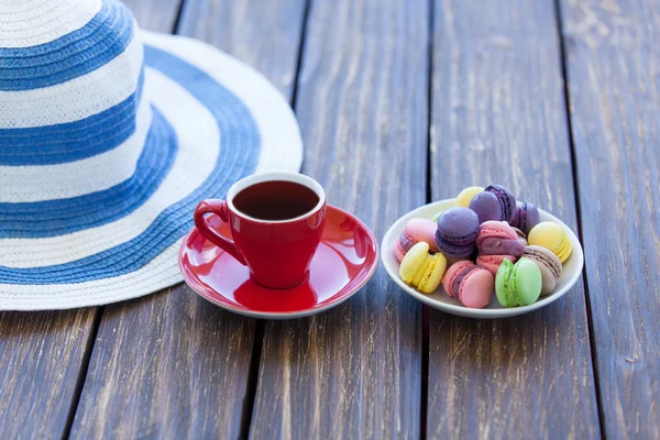 Cup of coffee and macarons with hat — Stock Photo, Image