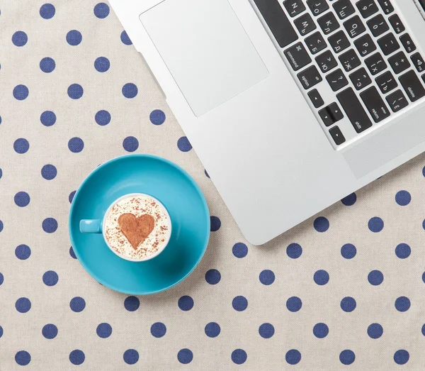 Cup of cappuccino with and laptop — Stock Photo, Image