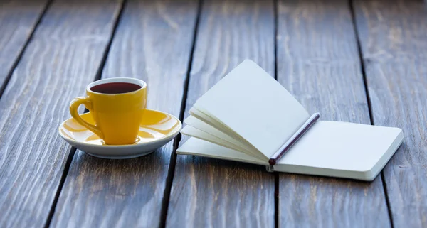 Tasse de café et carnet avec crayon — Photo