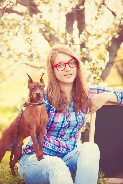 Junges Teenie-Mädchen mit roter Brille und Hund — Stockfoto