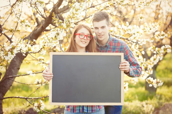 Young teen couple with blackboard — Stock Photo, Image