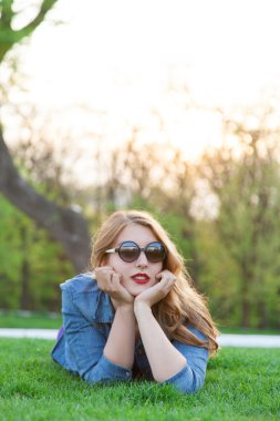 Yeşil çimenlerin üzerinde uzanmış kadın