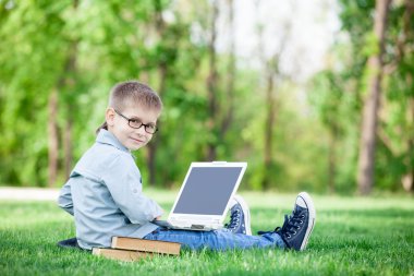 bir kitap olan çocuk ve dizüstü bilgisayar 