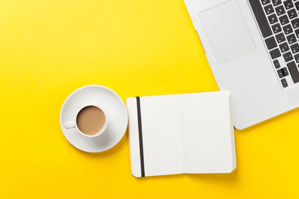 Tasse und Notizbuch neben Laptop — Stockfoto