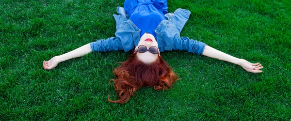 Woman lying down on green grass — Stock Photo, Image