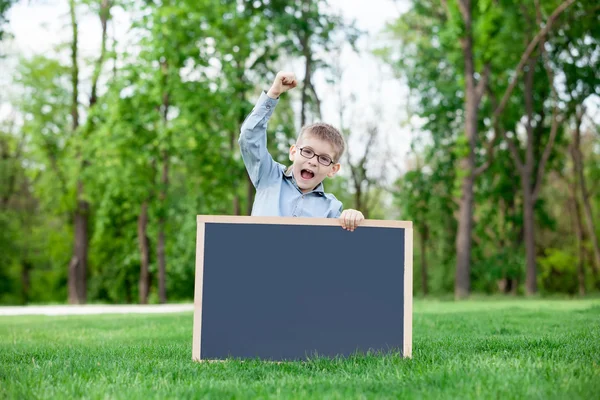 Jeune garçon avec un tableau noir — Photo