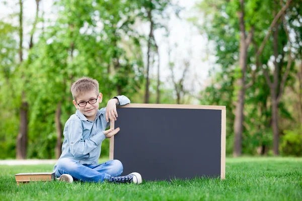 Jeune garçon avec un tableau noir — Photo