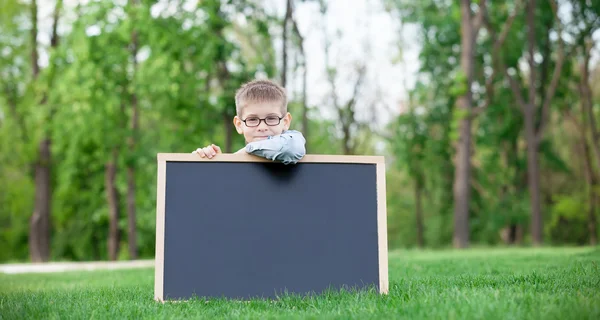 Jeune garçon avec un tableau noir — Photo