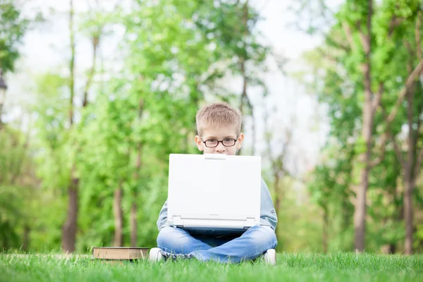 Мальчик с книгами и ноутбуком — стоковое фото