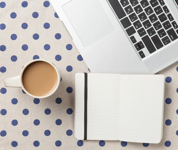 Tasse und Notizbuch neben Laptop — Stockfoto