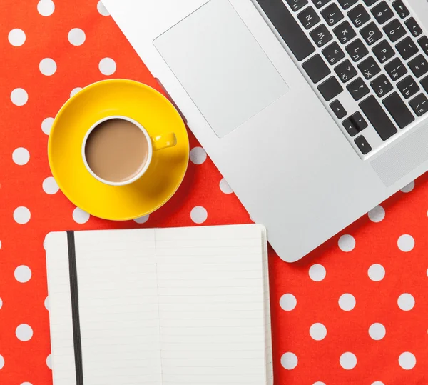 Tasse und Notizbuch neben Laptop — Stockfoto