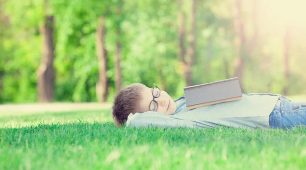 Chico joven con un libro deslizándose —  Fotos de Stock