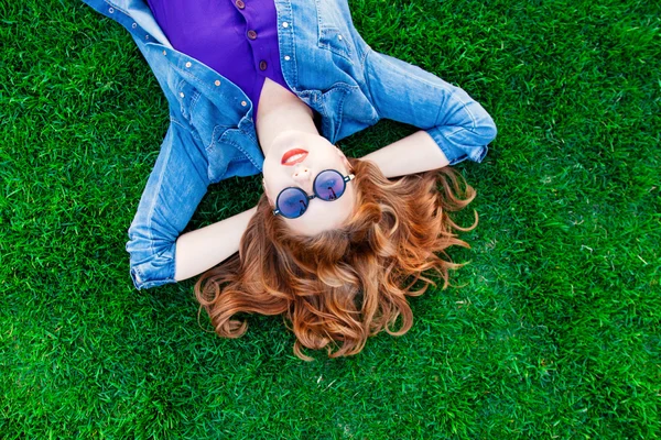 Vrouw liggen op groen gras — Stockfoto