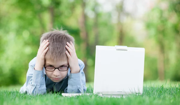 Jovem menino triste com computador portátil — Fotografia de Stock
