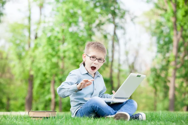 Мальчик с книгами и ноутбуком — стоковое фото