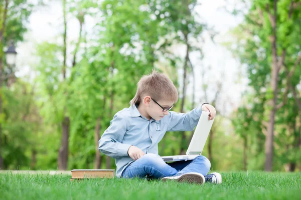 書籍を持つ少年とラップトップ コンピューター — ストック写真