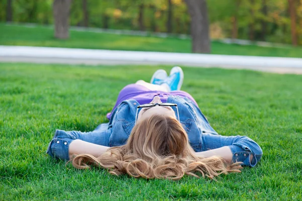 Woman lying down on green grass — Stock Photo, Image