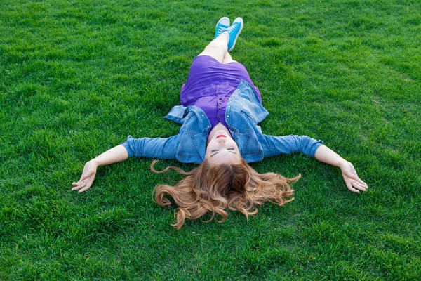 Yeşil çimenlerin üzerinde uzanmış kadın — Stok fotoğraf