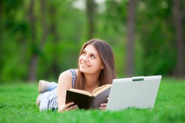 Dizüstü bilgisayar ve kitap ile kız