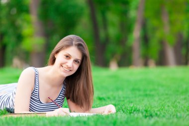 Yeşil çimenlerin üzerinde kitap kızla