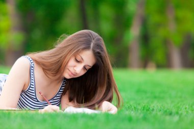 Yeşil çimenlerin üzerinde kitap kızla